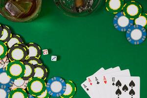 jeu, fortune et divertissement concept - proche en haut de casino puces, whisky verre, en jouant cartes et cigare sur vert table surface photo