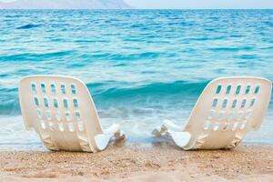 paysage de deux solitaire chaises de plage près le mer photo