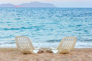 paysage de deux solitaire chaises de plage près le mer photo