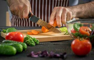 Masculin mains Coupe des légumes pour salade photo