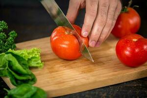 Masculin mains Coupe des légumes pour salade photo