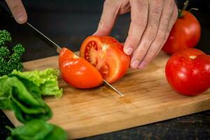 Masculin mains Coupe des légumes pour salade photo