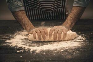 Masculin mains pétrir le pâte. photo