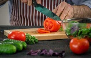 Masculin mains Coupe des légumes pour salade photo