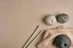 tricoté de une gris fil chandail et fil pour tricot fermer. tricot comme une passe-temps. accessoires pour tricot. photo