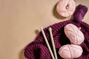 Trois rose tricot fil des balles, tricot aiguilles et et violet tricoté plaid Haut vue photo