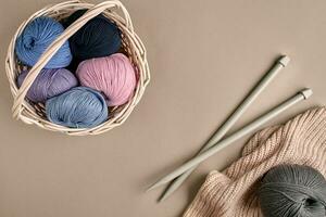 différent coloré fil dans panier avec tricot aiguilles. Haut vue photo