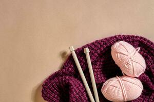 deux rose tricot fil des balles, tricot aiguilles et et violet tricoté plaid Haut vue photo