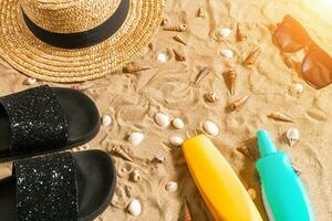 été tenue de plage, retourner flops, chapeau, des lunettes de soleil et coquillages sur le sable plage. photo