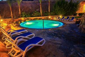 soir vue pour luxe nager bassin dans nuit éclairage photo