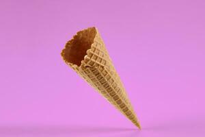 vide, délicieux tranche cône pour la glace crème contre rose Contexte. concept de nourriture, traite. maquette, modèle pour votre La publicité et conception. proche en haut photo
