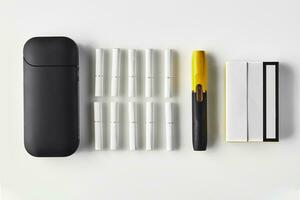 Nouveau génération noir et Jaune électronique cigarette et batterie, un pack et Dix bâtons chauffants isolé sur blanche. chauffage le tabac système. proche en haut photo