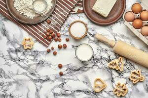 fermer tir. Haut vue de une cuisson Ingrédients et ustensiles de cuisine sur le marbre table Contexte. photo