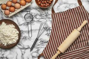 fermer tir. Haut vue de une cuisson Ingrédients et ustensiles de cuisine sur le marbre table Contexte. photo