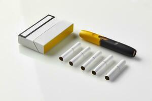 Nouveau génération noir et Jaune électronique cigarette, pack et cinq bâtons chauffants isolé sur blanche. La publicité zone. chauffage le tabac système. proche en haut photo