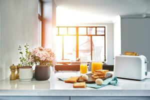 grille-pain avec Frais griller, des œufs et verre de Orange jus sur une lumière cuisine tableau. Soleil éclater photo