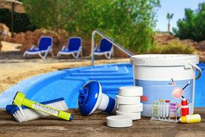 équipement avec chimique nettoyage des produits et outils pour le entretien de le nager bassin. photo