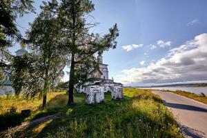 vieux orthodoxe église à village. été vue avec floral prairie. Soleil éclater photo