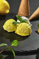 savoureux crémeux et citron la glace crème décoré avec menthe servi sur une pierre ardoise plus de une noir Contexte. photo