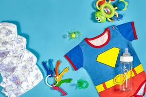 bébé vêtements, articles de toilette, jouets et santé se soucier accessoires sur bleu Contexte. photo