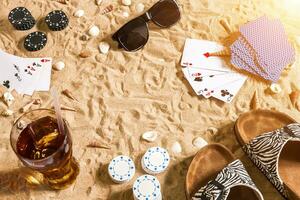 poker de plage. frites et cartes sur le sable. autour le coquillages, des lunettes de soleil et retourner flops. Haut vue photo