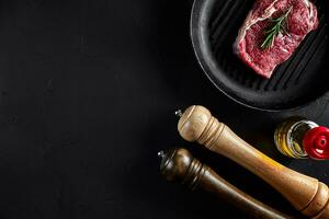 Frais brut Viande. du boeuf filet et marbré du boeuf steaks sur gril la poêle et friture planche avec assaisonnement, noir Contexte Haut voir. photo