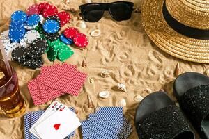 poker de plage. frites et cartes sur le sable. autour le coquillages, des lunettes de soleil et retourner flops. Haut vue photo