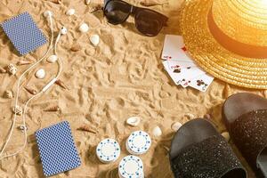 poker de plage. frites et cartes sur le sable. autour le coquillages, des lunettes de soleil et retourner flops. Haut vue photo