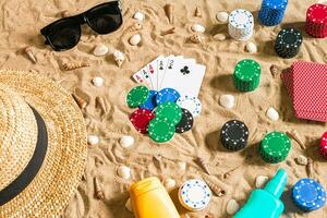 poker de plage. frites et cartes sur le sable. autour le coquillages, des lunettes de soleil et chapeau. Haut vue photo