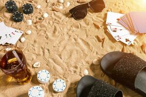 poker de plage. frites et cartes sur le sable. autour le coquillages, des lunettes de soleil et retourner flops. Haut vue photo