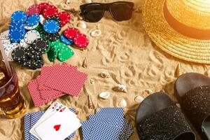 poker de plage. frites et cartes sur le sable. autour le coquillages, des lunettes de soleil et retourner flops. Haut vue photo