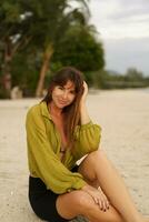 attrayant brunette femme dans élégant décontractée été tenue posant sur le tropical plage pendant les vacances. photo
