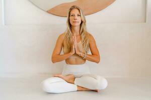 Jeune blond femme Faire yoga des exercices et pratiquant méditation. photo