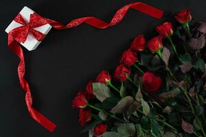 rouge des roses et cadeau boîte sur noir Contexte photo