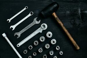 plat allonger de ensemble de outils pour voiture réparer tel comme clés sur noir en bois Contexte. Haut voir. photo