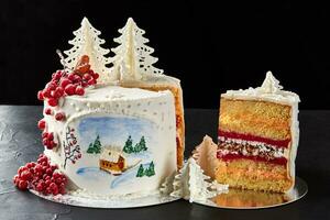 hiver gâteau couvert avec blanc glaçage, avec peint maison dans le forêt, des arbres et rouge sorbier des oiseleurs. photo