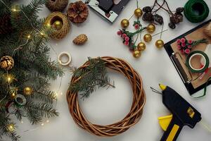 Noël Contexte avec décorations, guirlande et pin cônes. création couronne fabriqué de Noël arbre branches sur blanc Contexte. photo