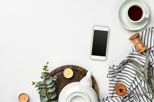 encore la vie avec thé tasse et le Contenu de une espace de travail composé. différent objets sur blanc tableau. plat allonger photo