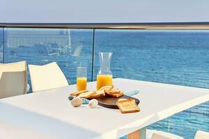 table pour deux servi avec une petit déjeuner sur Extérieur Hôtel balcon avec une mer voir. photo