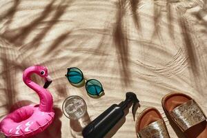 voyageur vacances accessoires sont posé en dehors sur une blanc plage sable. plat poser, Haut voir. photo