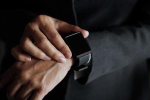 homme d'affaires appuyez sur le bouton pour trouver un emploi sur une montre intelligente en main photo