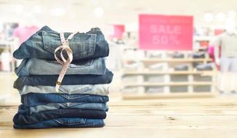 Jeans avec mesure en boutique sur étagère en bois et fond blanc photo
