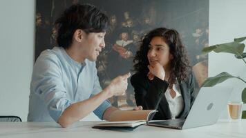 femme et homme à table avec un ordinateur portable ayant une conversation photo