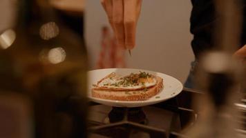 Mains de femme organisant des oeufs frits et de la ciboulette sur sandwich photo