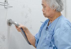 femme senior asiatique patient utiliser toilettes salle de bain poignée sécurité photo