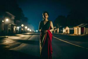 une femme dans une rouge sari permanent dans le milieu de une rue à nuit. généré par ai photo