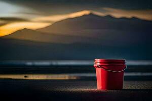 une rouge seau est assis sur le plage avec montagnes dans le Contexte. généré par ai photo