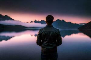 une homme permanent dans de face de une Lac à le coucher du soleil. généré par ai photo