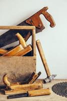 vieille boîte à outils en bois pleine d'outils. vieux outils de menuiserie. nature morte photo