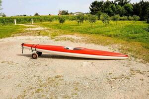 une rouge et blanc kayak sur le sol photo